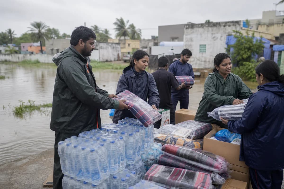 Volunteers preparing water, blankets and essential supplies near a flooded neighbourhood.